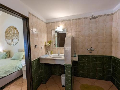 a bathroom with a sink and a bed at Casa do Palmeiral - Hoom B&B in Montes de Cima
