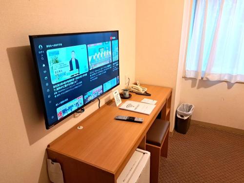 a desk with a computer monitor on top of it at Tetora Higashimuroran in Muroran