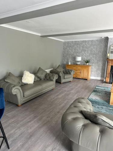 a living room with two couches and a table at Cameron Coach House Modern Property in Murrayfield Edinburgh in Edinburgh