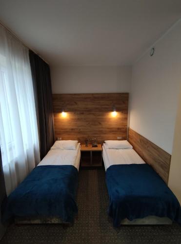 a hotel room with two beds and a desk at S7 Hotel in Kielce