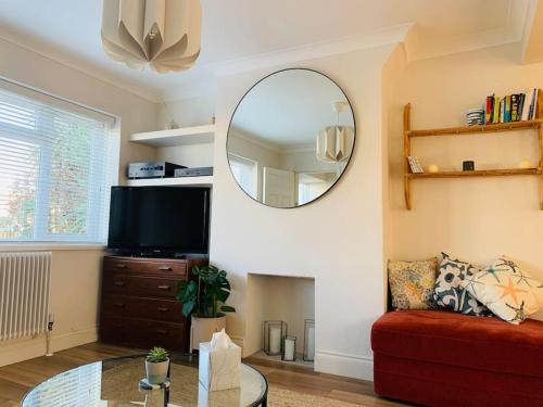 a living room with a red couch and a mirror at Whitstable contemporary cosy home with parking in Kent
