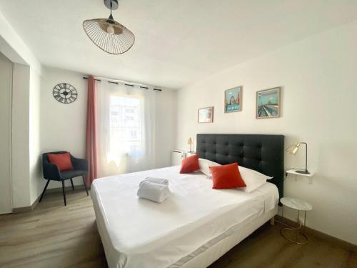 une chambre avec un grand lit blanc avec des oreillers rouges dans l'établissement Le Chaleureux - Studio proche du Jardin Compans, à Toulouse