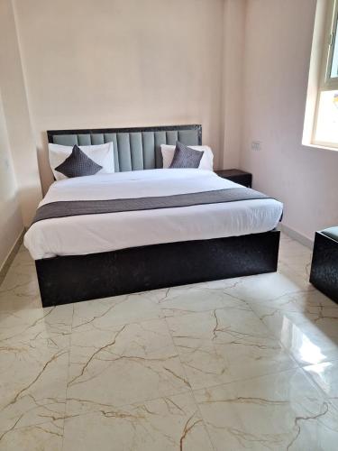 a large bed in a bedroom with a marble floor at Hotel Madhav Inn Top Family Hotels Business Hotels Best Couple Friendly Hotel in Lucknow in Lucknow