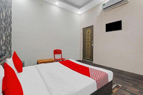 a bedroom with a red and white bed and a chair at Hotel Madhav Inn Top Family Hotels Business Hotels Best Couple Friendly Hotel in Lucknow in Lucknow