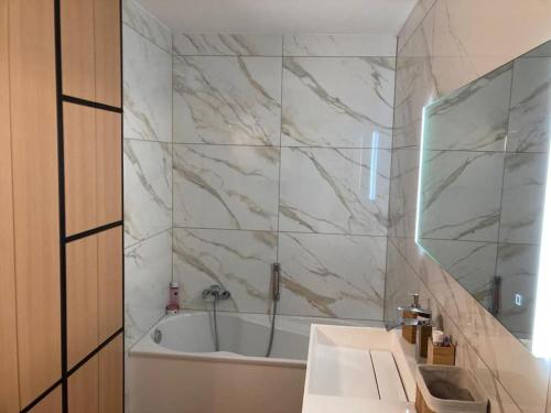 ChaffoursにあるAppartement moderne flambant neufの浴槽と洗面台とバスタブを備えたバスルーム