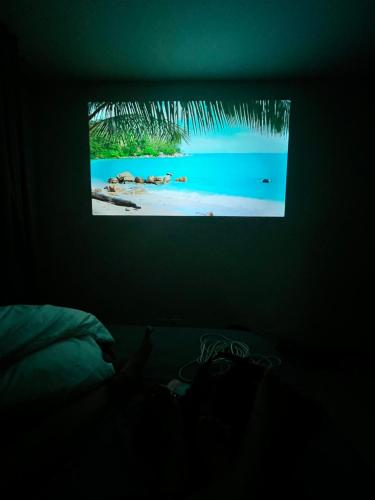 ein Schlafzimmer mit einem TV mit einem Bild vom Strand in der Unterkunft Condo with resort-like living, everyday in Lapu Lapu City