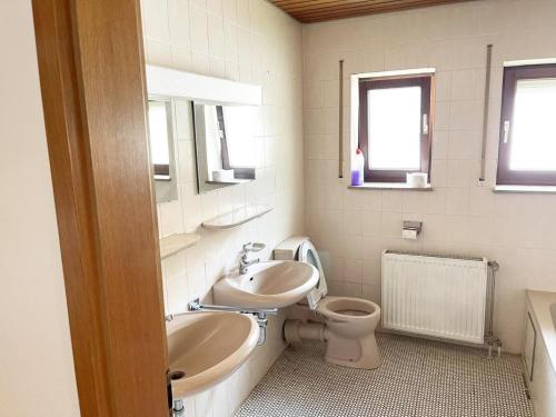 een badkamer met een wastafel, een toilet en een bad bij Gemütliche Apartments mit Balkon in Niederstotzingen