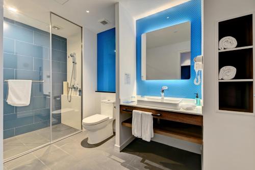 ein Badezimmer mit einem WC, einem Waschbecken und einem Spiegel in der Unterkunft Holiday Inn Express Xiamen Airport Zone, an IHG Hotel in Xiamen