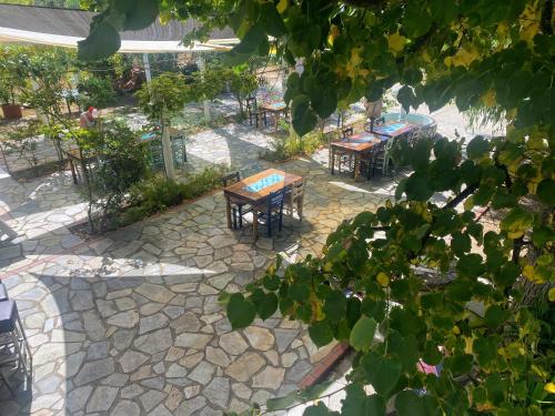 a patio with tables and chairs in a garden at Blue Bay Beach Hotel in Kinira