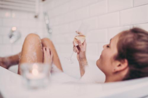 Una donna è seduta in una vasca da bagno di First Hotel Millennium a Oslo