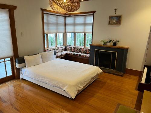 a bedroom with a white bed and a fireplace at Bayswater Homestay in Auckland