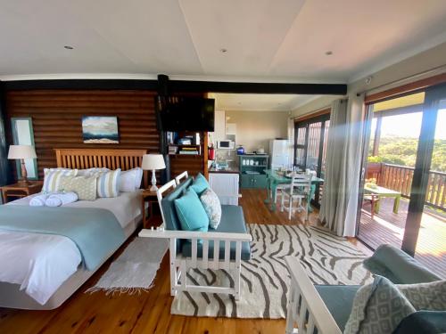 a bedroom with a bed and a living room at Tiptol Couple's Retreat in Jeffreys Bay