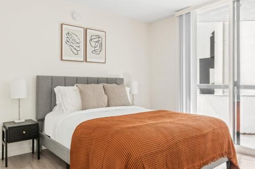 Un dormitorio con una cama con una manta naranja. en Hollywood 2BR w Gym Pool Lounge nr the 101 LAX-730, en Los Ángeles
