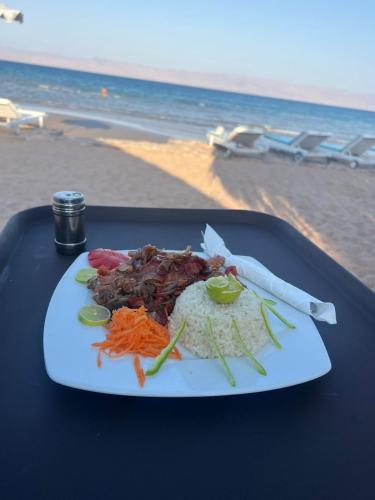 a plate of food on a table next to the beach at Panorama Lodge Nuweiba in Nuweiba