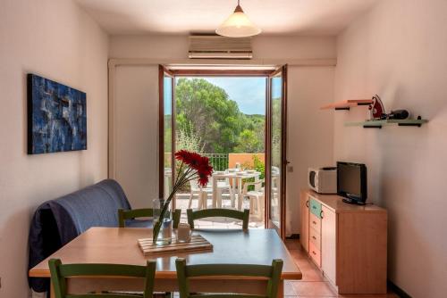 a dining room with a table and a view of a patio at Glorious Residence Le Pavoncelle one Bedroom sleeps four child num1450 in Santa Teresa Gallura
