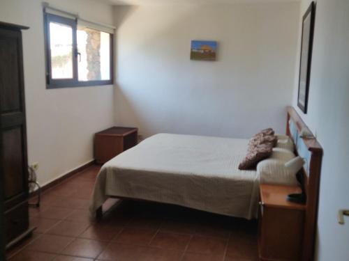 a small bedroom with a bed and a window at CASA LA TAHONILLA in Tías