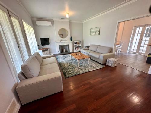 a living room with a couch and a table at Jacaranda Cottage in Broadwater