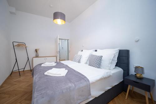 a bedroom with a large white bed with towels on it at CoView - Bautzen - Design Apartment in der Altstadt mit Terrasse und fantastischem Ausblick in Bautzen