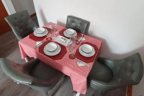 a table with a red table cloth with plates and dishes on it at New Bubble Apartments in London