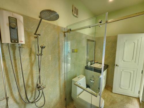 a bathroom with a shower and a toilet at Blue Beach Bungalow in Bang Saphan Noi