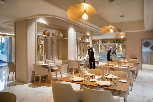 a restaurant with a large wooden table and chairs at Hotel Riu Gran Canaria - All Inclusive in Maspalomas