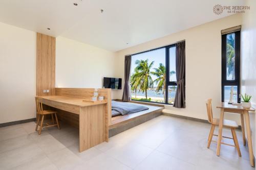 a bedroom with a bed and a desk and a window at The Rebirth Apartment Binh Chau Ho Tram in Ba Ria