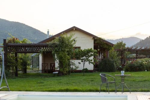 a house with a table and chairs in the yard at Casa TaMi in Piatra Neamţ