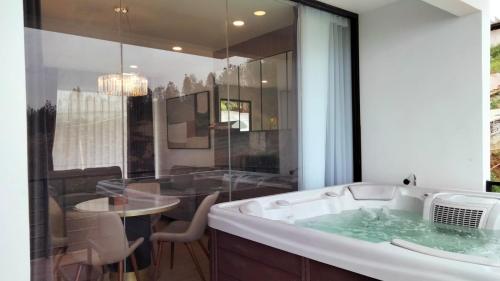 uma casa de banho com banheira, mesa e cadeiras em Hotel Nature Bromo and Resort em Pasuruan