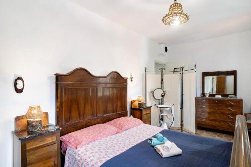 1 dormitorio con 1 cama con cabecero de madera y vestidor en Câ de Bacî, en Vessalico