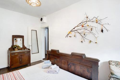 a bedroom with a bed and a branch on the wall at Câ de Bacî in Vessalico