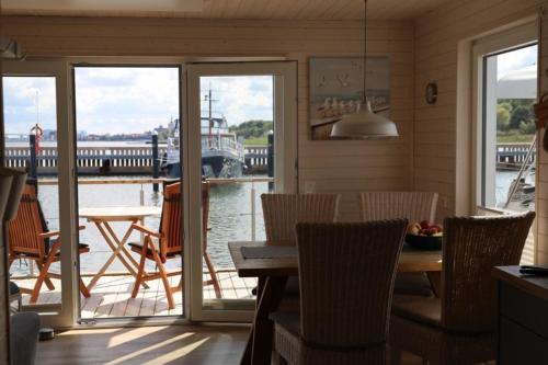 a dining room with a table and chairs and a boat at Hausboot Liliput in Stralsund