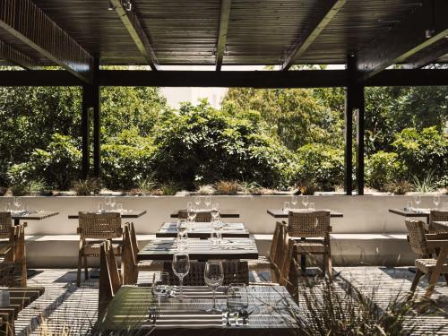 an outdoor dining area with tables and chairs at Lindian Village All Inclusive Resort Rhodes,Curio Collection in Kiotari