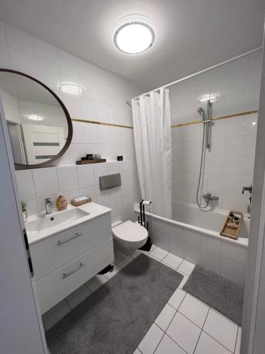a bathroom with a sink and a toilet and a shower at Moderne Galerie-Wohnung! Zentral-A8-B17 WIFI in Gersthofen
