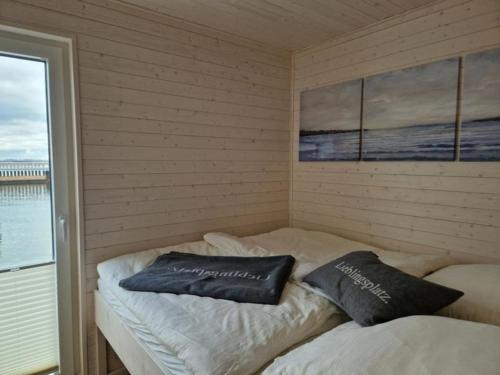 two pillows sitting on a bed in a room at Hausboot Liliput in Stralsund