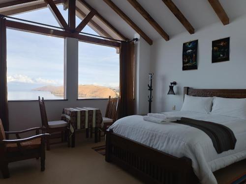 a bedroom with a bed and a large window at Sol y Luna ISLA DEL SOL in Comunidad Yumani