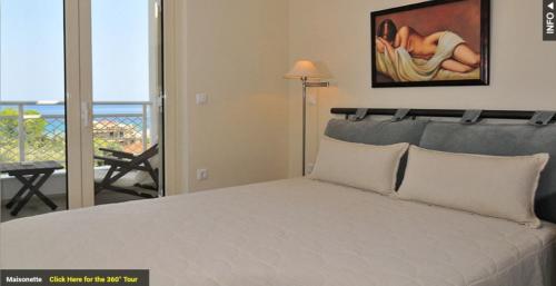 1 dormitorio con 1 cama y vistas al océano en Maisonettes Athina, en Chrysi Ammoudia