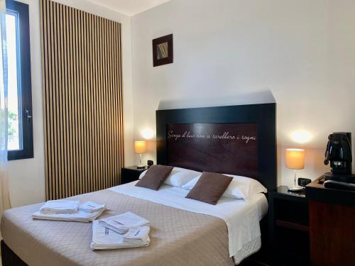 una camera d'albergo con un letto e asciugamani di B&B Casanova a Minervino di Lecce