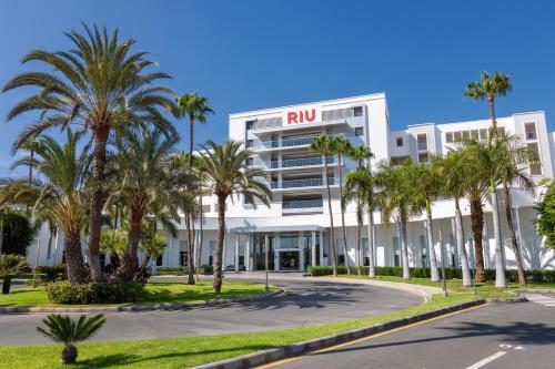 a building with palm trees in front of it at Hotel Riu Gran Canaria - All Inclusive in Maspalomas