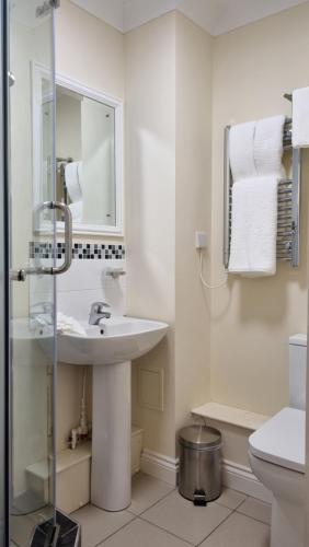 Baño blanco con lavabo y aseo en Royal Swan, Ashley Manor - Bed and Breakfast, en Shedfield