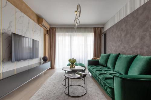 a living room with a green couch and a table at Urbanstay Suites - Prime Location Designer Suite in Bucharest