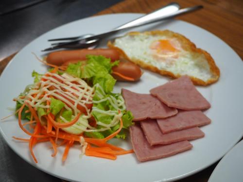 尖竹汶IP Plus Resort Chanthaburia - Halal Hotel的盘子,包括肉、沙拉和烤面包