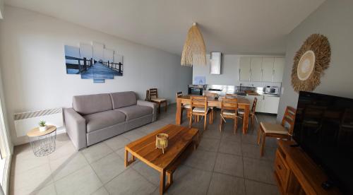 un salon avec un canapé et une table dans l'établissement Résidence Pasino, à Lacanau-Océan