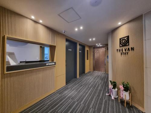 a hallway of an office with a tv and plants at The Van Stay in Busan