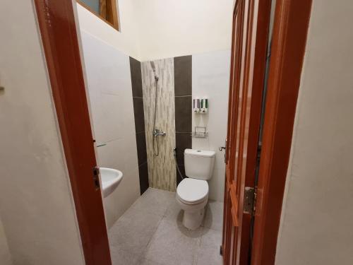 a small bathroom with a toilet and a sink at Omah Nayan in Yogyakarta