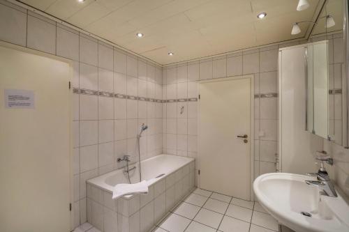 Baño blanco con bañera y lavamanos en mit Wintergarten nah Moviepark en Bottrop