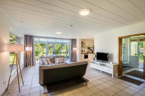 uma sala de estar com um sofá e uma televisão em mit Wintergarten nah Moviepark em Bottrop