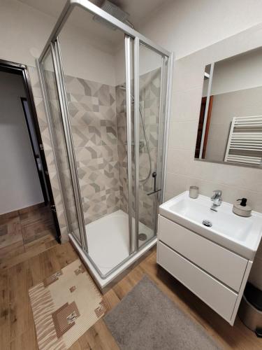 uma casa de banho com um chuveiro e um lavatório. em Poľovnícka chata Štefana em Mlynky 