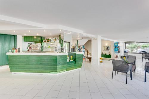 a restaurant with a green counter and some chairs at Hotel Costaverde in Cesenatico