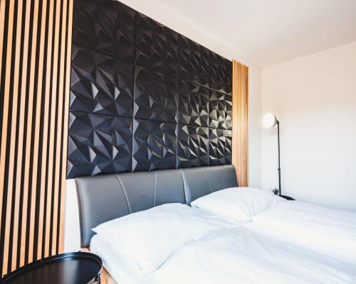 a bedroom with a bed and a black headboard at Villa Gall in Český Krumlov