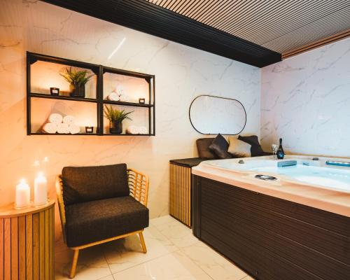 a bathroom with a tub and a chair in it at Villa Gall in Český Krumlov